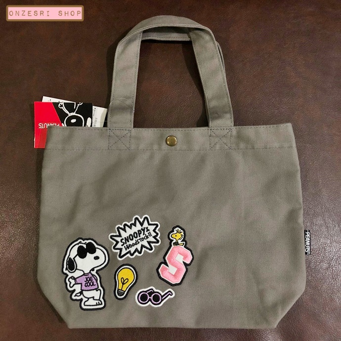 กระเป๋า Snoopy สีเทา ผ้าหนา ด้านนอกปะลายปัก ด้านในมีซับ มีกระดุมแป๊กปิดเปิด ขนาด 34 x 20 x 10 ซม.