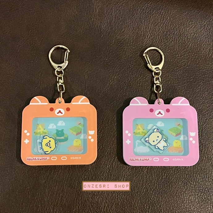 พวงกุญแจ Rilakkuma Gaming Collection Acrylic Shaka Shaka (Limited) ขนาด 8 x 7.5 ซม. ไม่มีขายทั่วไป เป็นแบบต้องลุ้นกับทางหน้าร้าน San-X ที่ญี่ปุ่นเท่านั้น มี 2 แบบให้เลือก