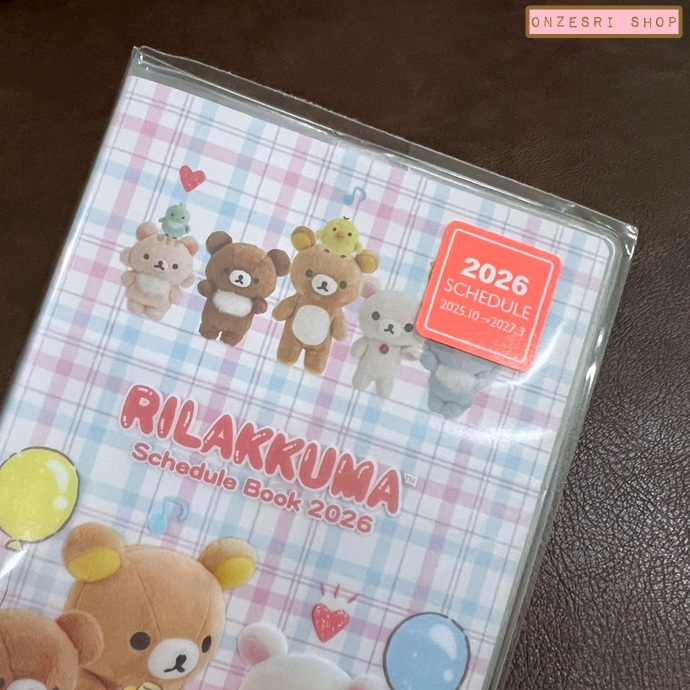 สมุด 2026 Schedule Book เล่มกลาง A6 ลาย Rilakkuma สีขาว ขนาด 10.8 x 15.5 x 0.6 ซม. (64 หน้า) มีให้จดตั้งแต่เดือน 10/2025 - 3/2027 เป็นปฎิทินแบบ monthly ช่องกลาง ด้านหน้าเป็นช่อง pocket ใส่ของได้